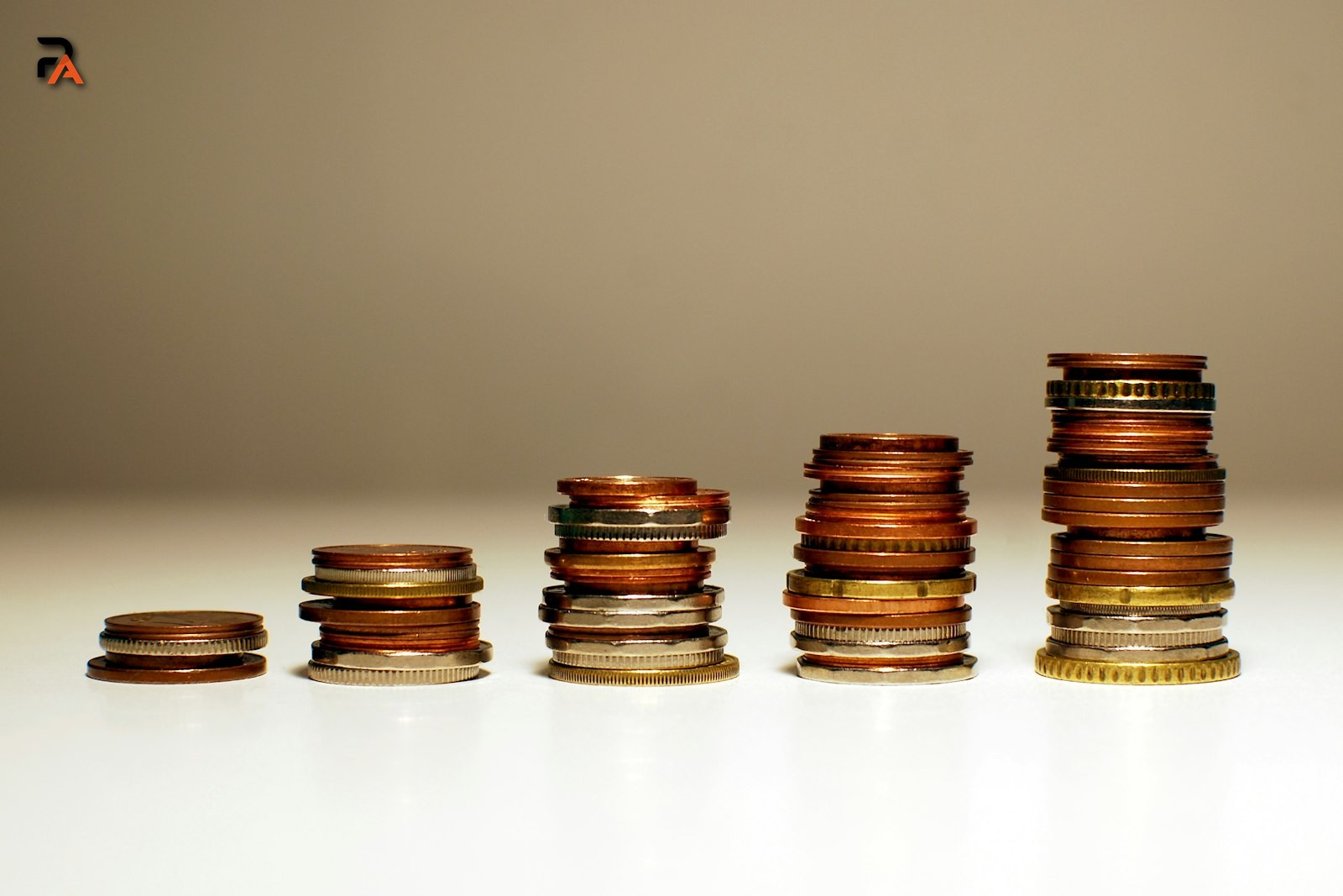 Coin stacks increasing in height, illustrating how money grows faster under compound interest